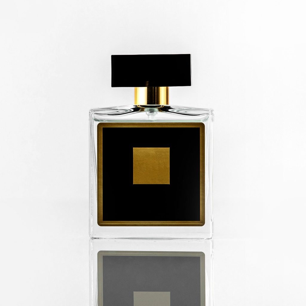 une-bouteille-de-parfum-noir-vue-de-face-avec-un-design-jaune-isole-sur-le-mur-blanc